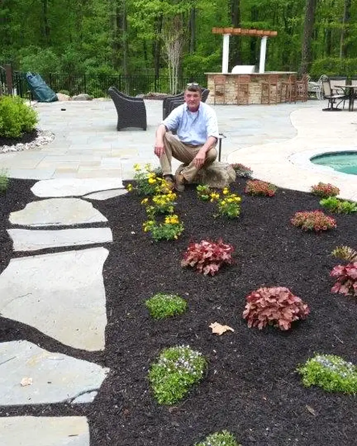 Robert O'Sullivan beside a finished garden, flagstone path and pool terrace